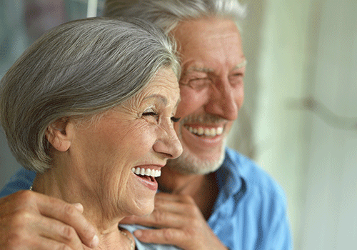 Older couple enjoying long lasting results of dental implants